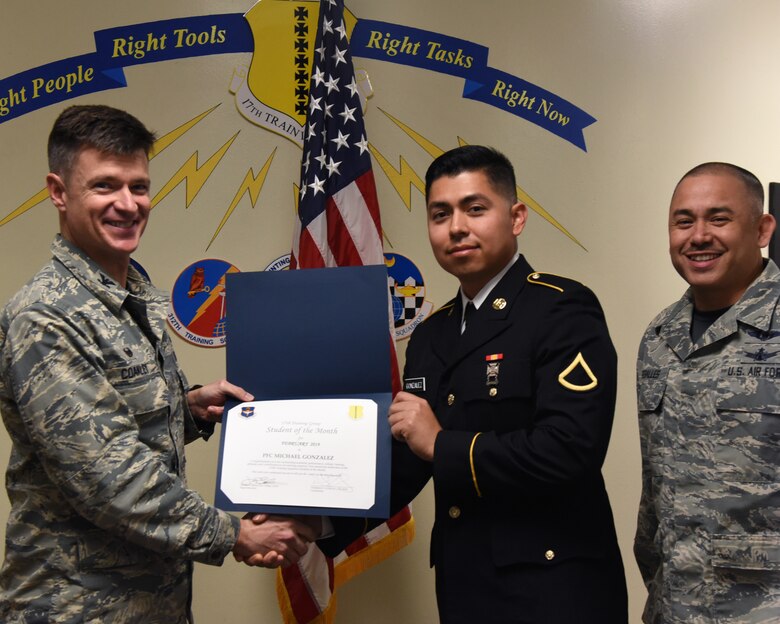 U.S. Air Force Col. Thomas Coakley, 17th Training Group commander, presents the 312th Training Squadron Student of the Month award to Private 1st Class Michael Gonzalez, 312th TRS student, at Brandenburg Hall on Goodfellow Air Force Base, Texas, March, 1, 2019. The 312th TRS’s mission is to provide Department of Defense and international customers with mission ready fire protection and special instruments graduates and provide mission support for the Air Force Technical Applications Center. (U.S. Air Force photo by Airman 1st Class Abbey Rieves/Released)