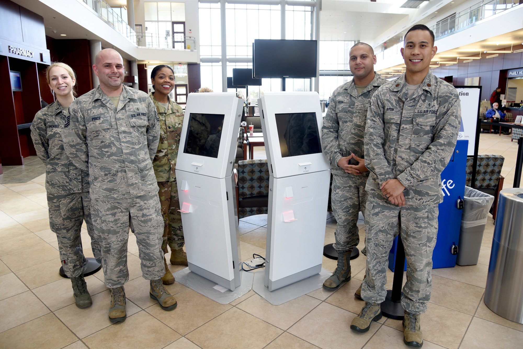 72nd Medical Support Squadron members, from left, First Lt. Jordan Pickell, Master Sgt. Gareth Price, Lt. Col. Theodosia Hill, commander; Tech. Sgt. Karvin Vega and Maj. Karl Bituin, diagnostics and therapeutics flight commander, were the main team members to bring the Q-Flow kiosks to fruition for pharmacy customers. Q-Flow allows customers to check-in to get their prescriptions and then sit in the lobby of the 72nd Medical Group to wait for their pick-up. Q-Flow will show wait times for each customer on the large screens, creating a virtual line, as opposed to standing in an actual line, to receive their prescriptions. (U.S. Air Force photo/Kelly White)