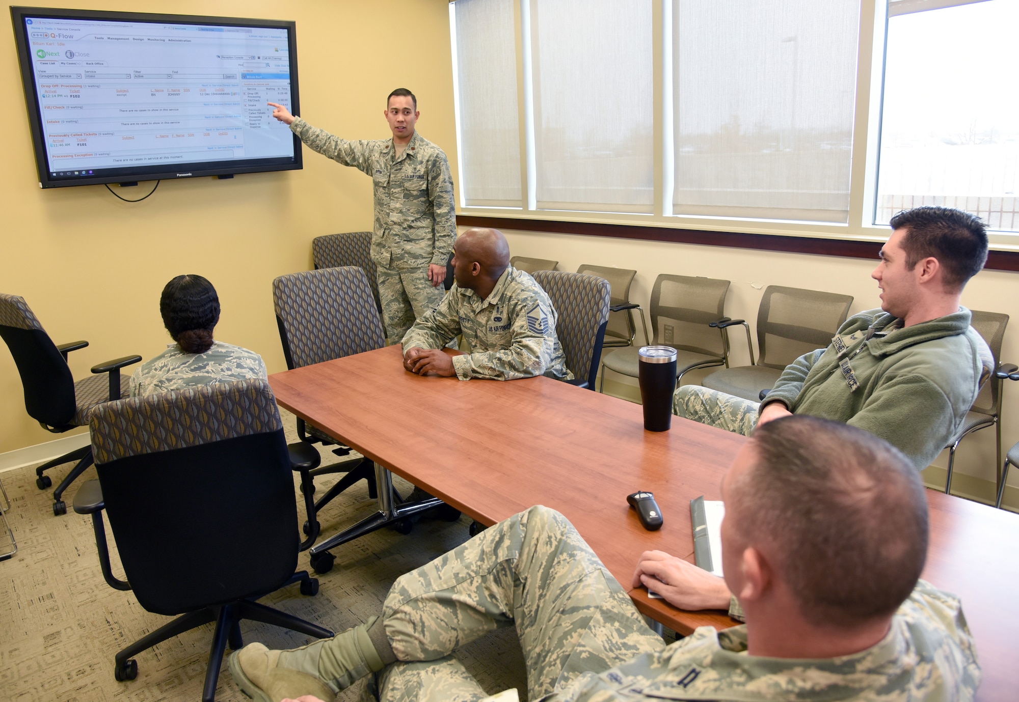 Maj. Karl Bituin, 72nd Medical Support Squadron diagnostics and therapeutics flight commander, guides members of the squadron through training on the new Q-Flow kiosk system for pharmacy prescriptions. (U.S. Air Force photo/Kelly White)