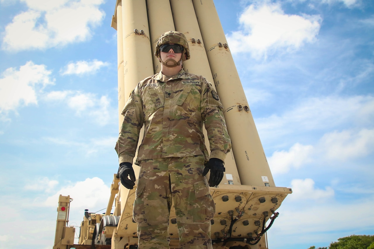 A Soldier stand in front of a Terminal High Altitude Area Defense system