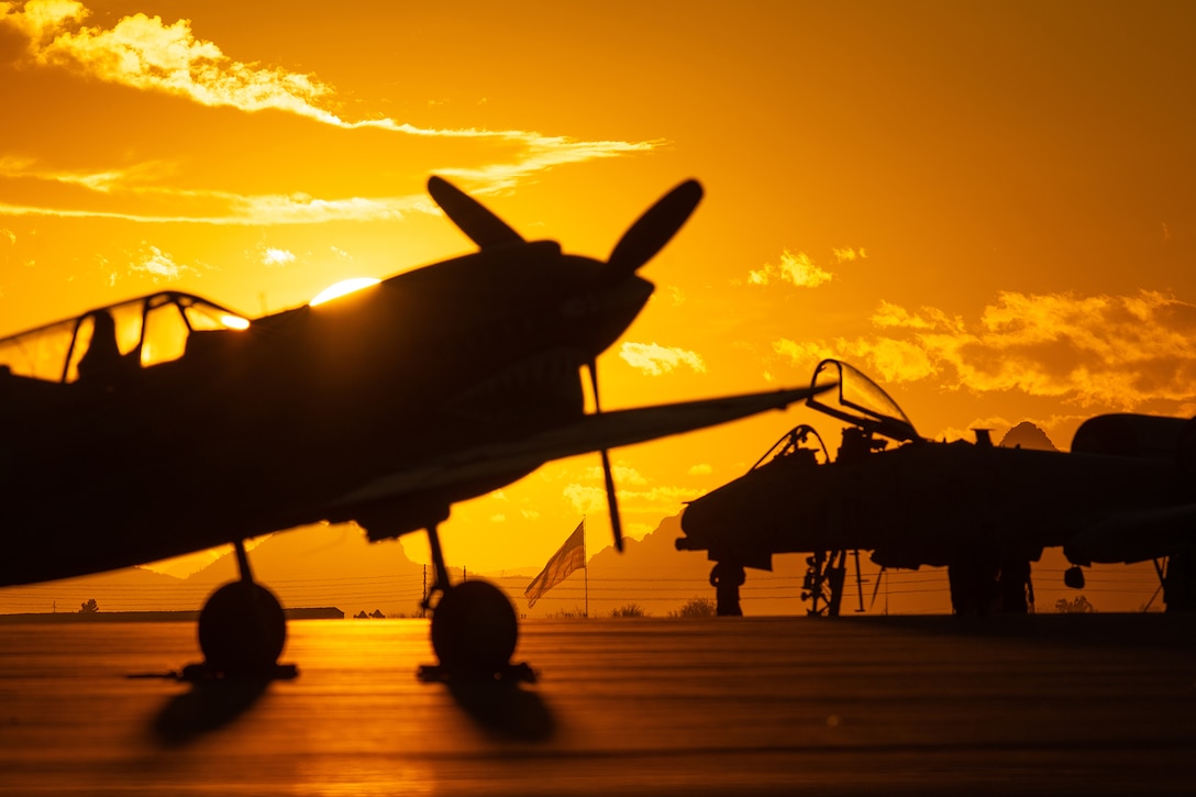 The sun sets behind an aircraft.