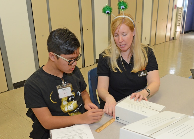 Janet Creech, STARBASE Instructional Systems specialist, shows a student how to calculate the volume of different boxes during the first day of STARBASE classes March 5, 2019. Edwards is one of nine active duty bases with an official STARBASE program. The STEM-based program familiarizes elementary students, primary fifth and sixth graders, from all backgrounds to the world of science, technology, engineering and mathematics. (U.S. Air Force photo by Kenji Thuloweit)