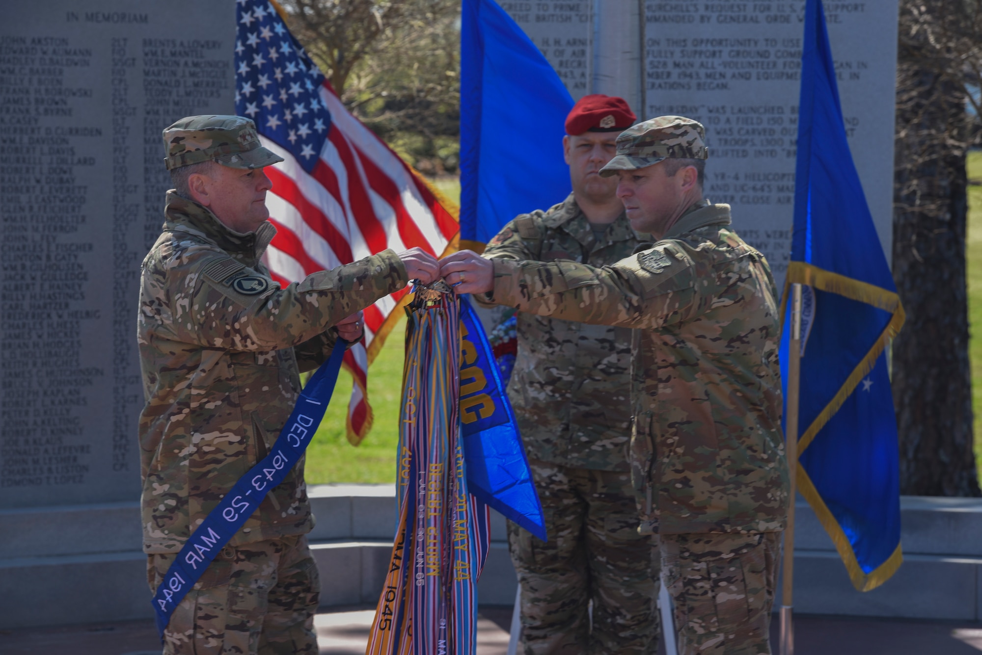 officers putting streamer on a guidon outside