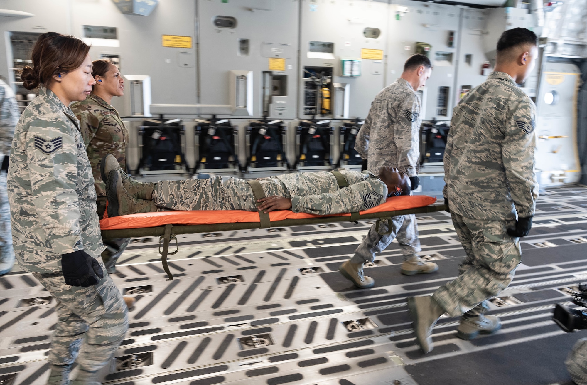 U.S. Air Force Master Sgt. Kassy Costales, back left, and Staff Sgt. Alexandria Davis carry the back end of the patient litter during a training scenario, both are members of the Air Force Reserve’s 624th Aeromedical Staging Squadron, at Joint Base Pearl Harbor-Hickam, Hawaii, March 3, 2019.