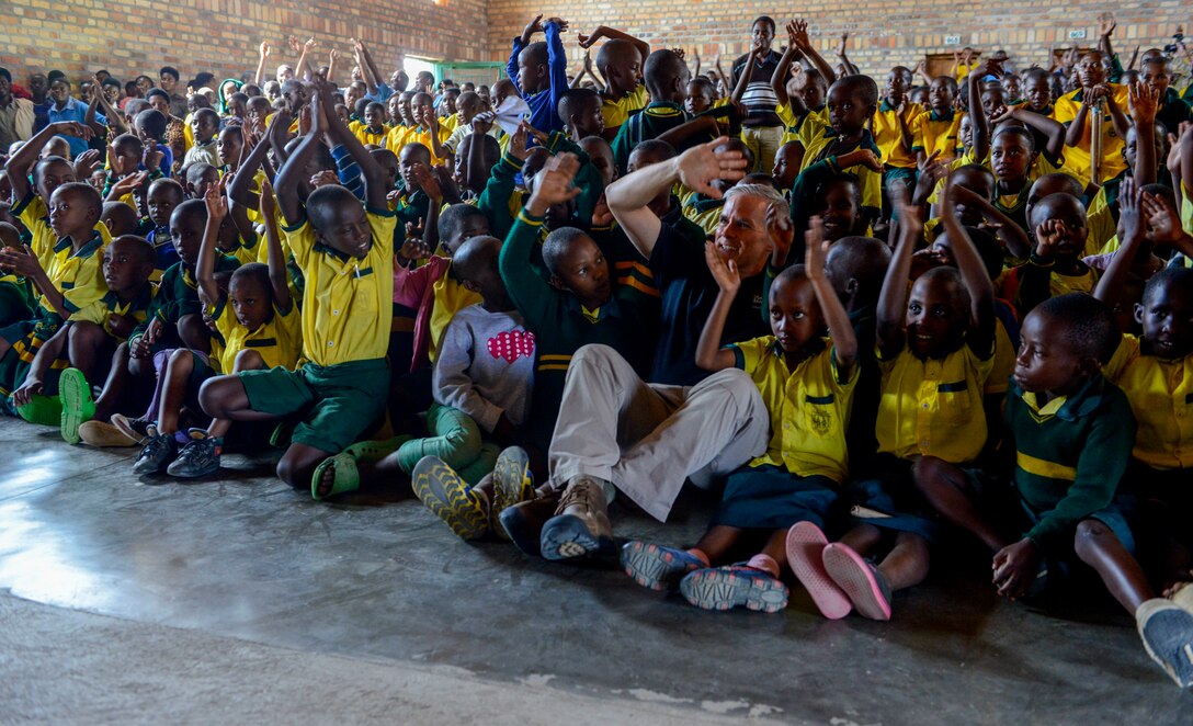 U.S. Air Force Tech. Sgt. Joseph Whitt, U.S. Air Forces in Europe Band bass player, sits with students at the Home de la vierge des Pauvres Gatagara/Nyanza in the Nyanza District, Rwanda, March 5, 2019. After playing music for the students, Whitt and other members of the USAFE Band joined the crowd to listen to some of the students sing a song. (U.S. Air Force photo by Tech. Sgt. Timothy Moore)