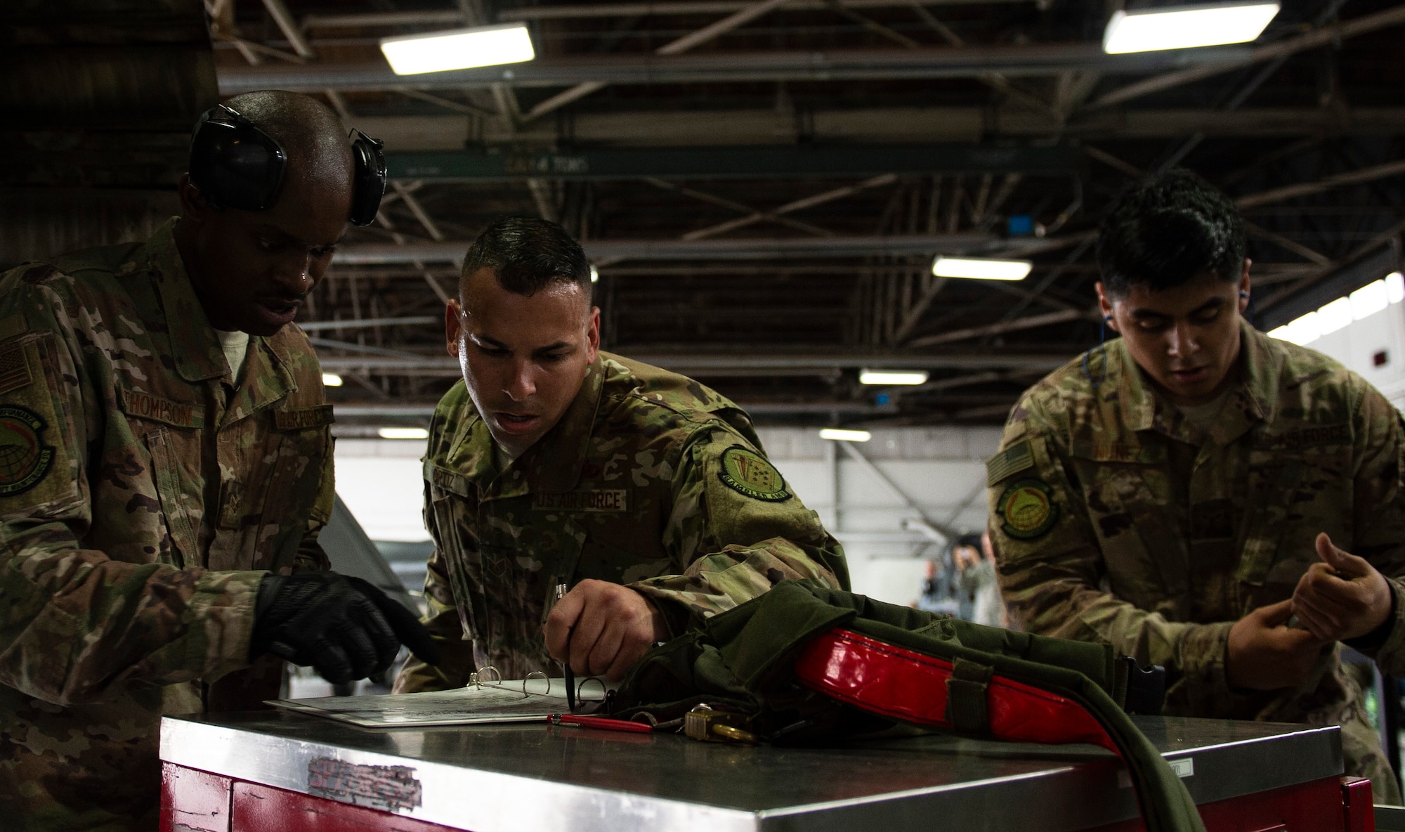 From left, U.S. Air Force Senior Airman Josef Thompson, Staff Sgt. Samuel Ortiz and Airman 1st Class Daniel Nunez, 20th Aircraft Maintenance Squadron, 77th Aircraft Maintenance Unit load crew, review paperwork following load-completion at Shaw Air Force Base, S.C., March 1, 2019.