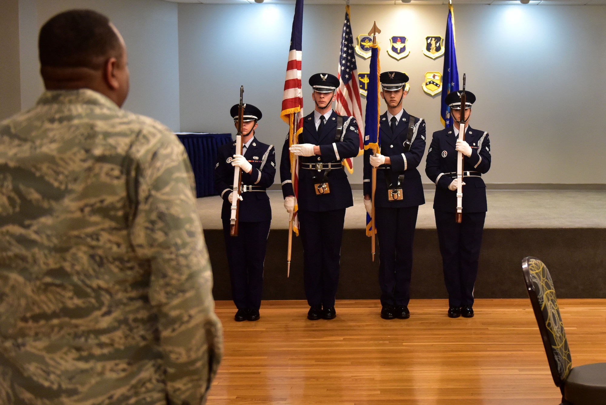 Four Airmen wearing honor guard uniforms present the colors.