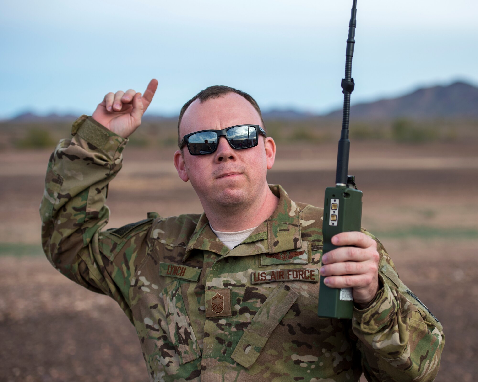 U.S. Air Force Senior Master Sgt. Steven Lynch, Flight Engineer Superintendent from the 109th Airlift Squadron, gives the signal to pop smoke during an airdrop mission at the Yuma Proving Grounds, Ariz. Feb. 26, 2019.