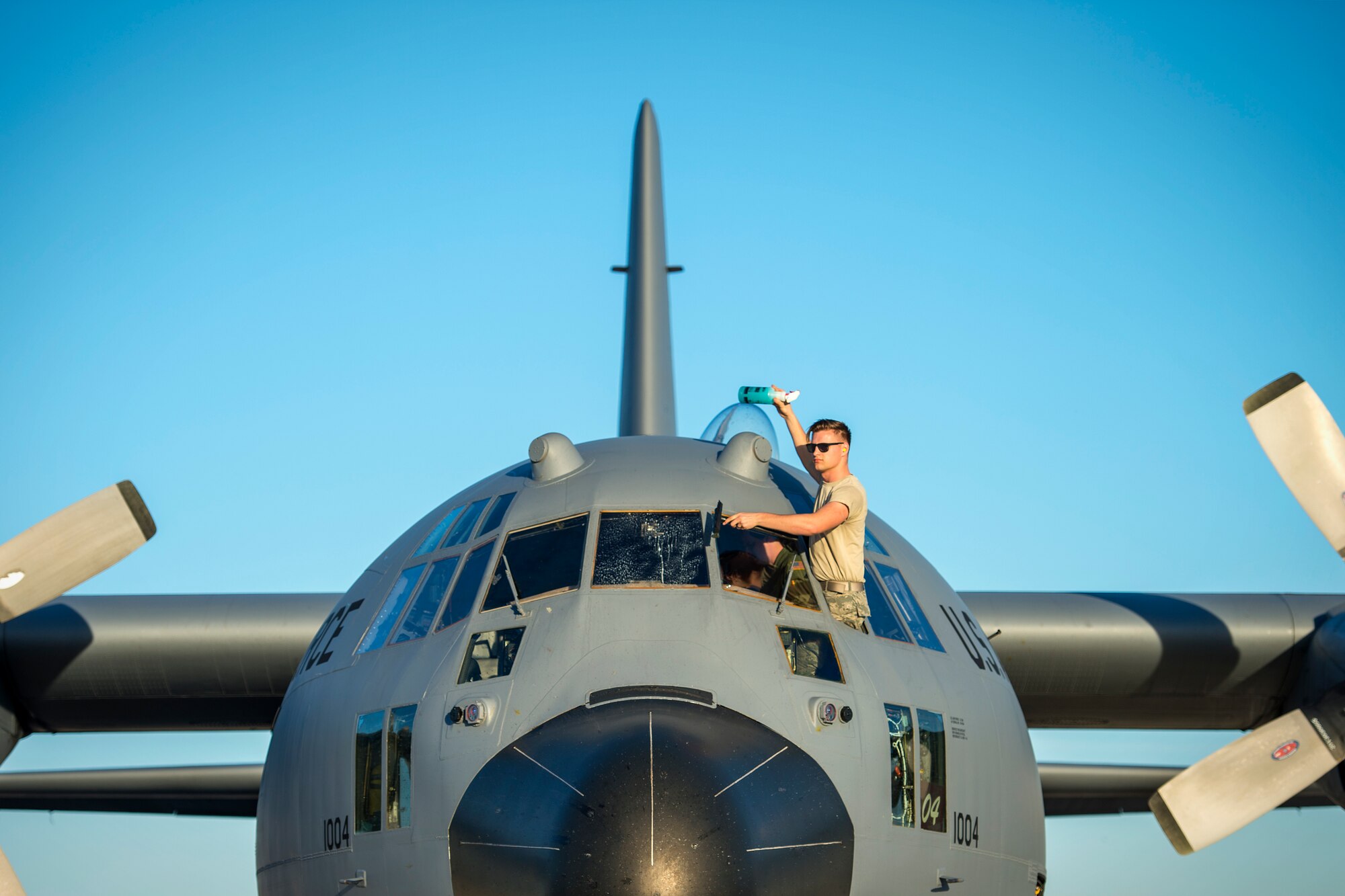 U.S. Air Force Senior Airman Daniel Hall, a crew chief from the 133rd Aircraft Maintenance squadron cleans the front window on a C-130 Hercules in Yuma, Ariz. Feb. 28, 2019.