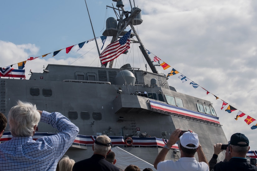 Attendees of the USS Charleston (LCS-18) commissioning ceremony take pictures as its flag is hoisted for the first time March 2, 2019, in Charleston, S.C.
