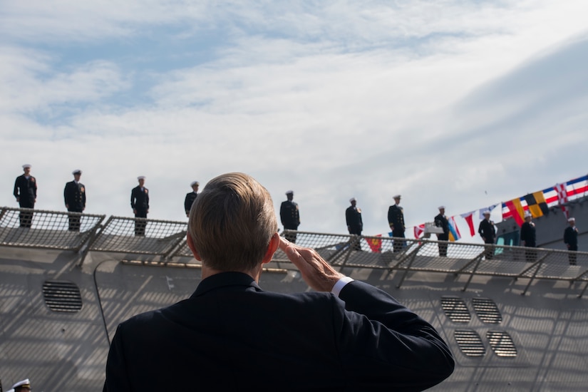 An attendee salutes USS Charleston (LCS-18) crew members as they officially man the ship for the first time at its commissioning ceremony March, 2, 2019, in Charleston, S.C.