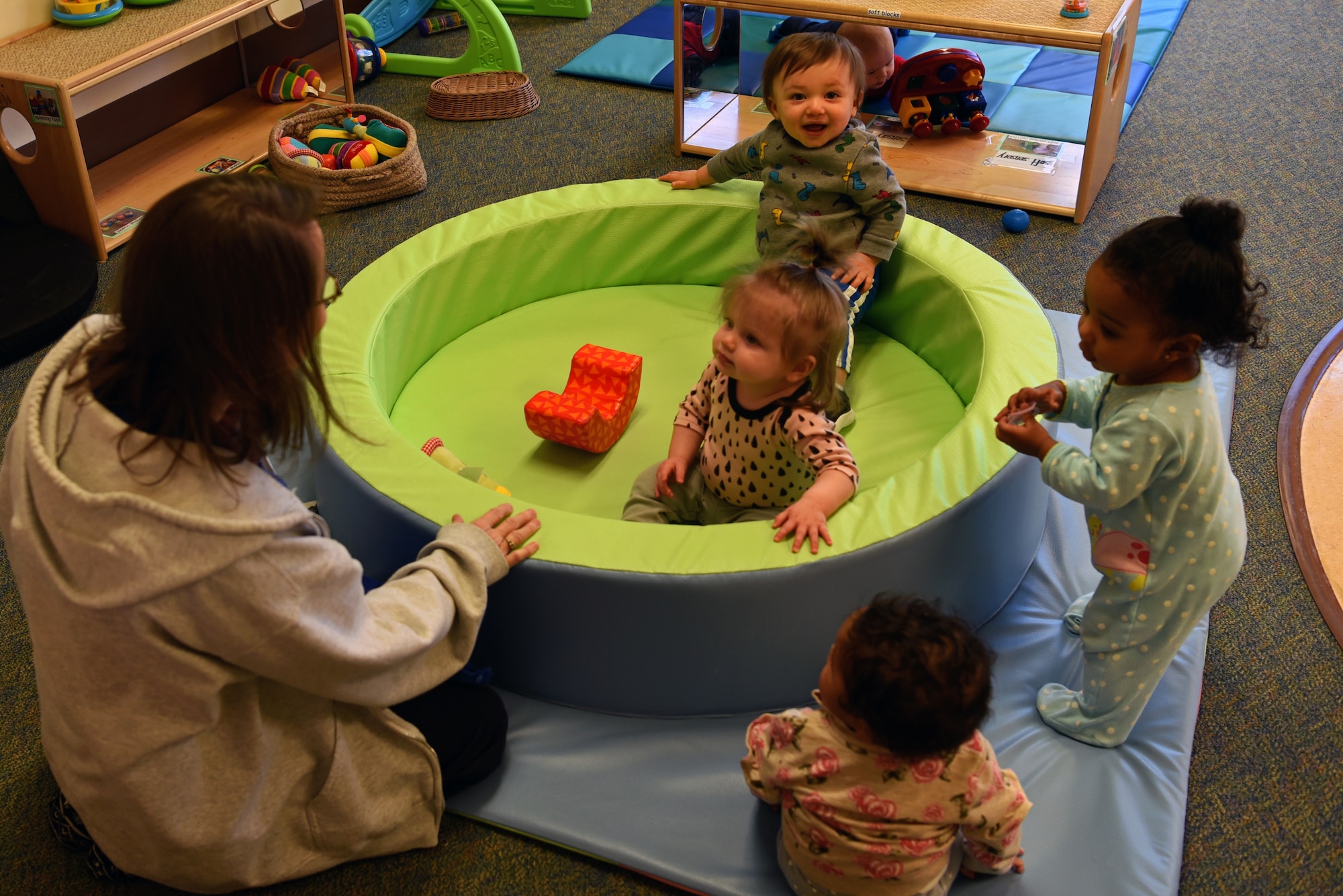 Amy Roberts, 20th Force Support Squadron Child Development Center (CDC) caregiver, plays with the infants in her care at Shaw Air Force Base, S.C., Feb. 25, 2019.