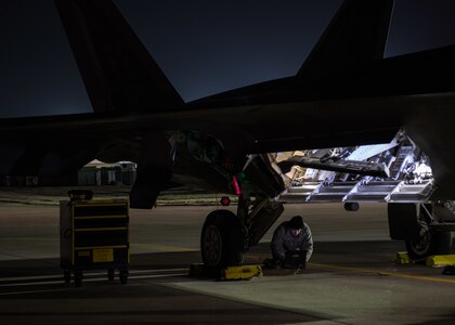 U.S. Air Force Airmen from the 1st Aircraft Maintenance Squadron check technical orders under an F-22 Raptor during a total force exercise at Joint Base Langley-Eustis, Virginia, Feb. 28, 2019.