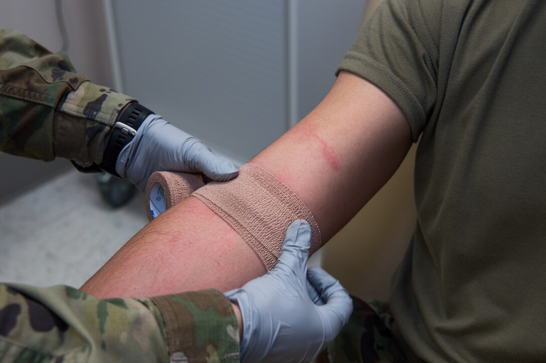 U.S. Army Sgt. Valeria Melton, McDonald Army Health Center NCO in charge of internal medicine, wraps the arm of Spc. Heaith Howe, McDonald Army Health Center radiology specialist, after giving him an IV at Joint Base Langley-Eustis, Virginia, Feb. 5, 2019.