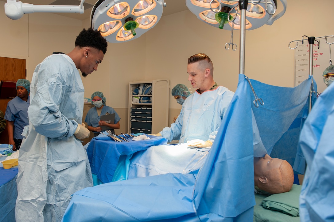 A service member and a basketball player prepare to perform a mock surgery.