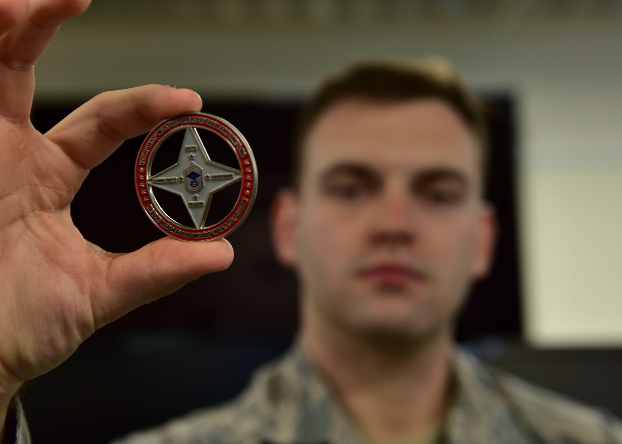 U.S. Air Force Staff Sgt. Brandon Nickell, 8th Intelligence Squadron intelligence analyst, holds a coin presented to him by Chief Master Sgt. James Worrell, 56th Air Communications Squadron superintendent, at Joint Base Pearl Harbor-Hickam, Hawaii, Feb. 25, 2019. Worrell credits Nickell’s quick response and care with saving his life. (U.S. Air Force photo by Staff Sgt. Eboni Prince)
