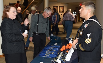 Nina McGrath, founding director of the San Antonio Youth Wind Ensemble, speaks with Petty Officer 1st Class Jose Zouain, assigned to Navy Recruiting Station San Marcos, during the U.S. Navy Band concert held in the Jackson Auditorium on the campus of Texas Lutheran University.  The U.S. Navy Band performed in 10 states during its 23-city, 5,000-mile tour, connecting communities across the nation to the Navy.