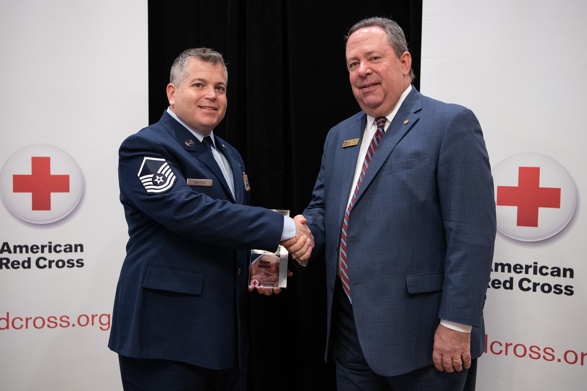 James Finch (right), First Fidelity Bank, shakes hands with Oklahoma Air National Guard Master Sgt. Bryan Whittle, assigned to the 205th Engineering and Installation Squadron at Will Rogers Air National Guard Base, Oklahoma City, after naming him as the American Red Cross of Oklahoma military hero of the year during the 2019 Heroes Breakfast in Oklahoma City, March 5, 2019. Whittle was one of eight people honored for actions in six categories – including military, first responder, healthcare professional, community impact, disaster services and youth – during the first ever Red Cross Heroes Breakfast in Oklahoma City. (U.S. Air National Guard Photo by Tech. Sgt. Kasey M. Phipps)