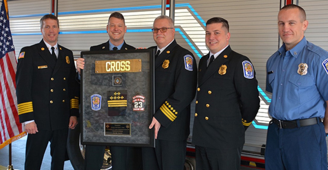 Cross stands with fellow firefighters at his retirement ceremony