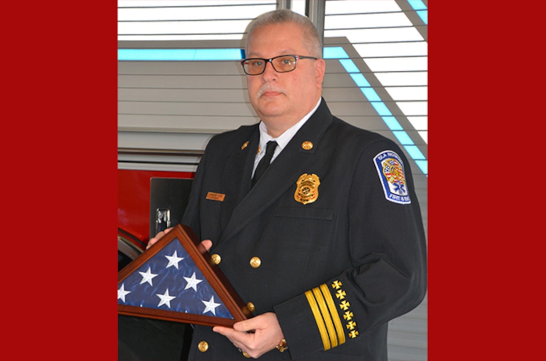 Cross stands with flag at his retirement ceremony