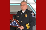 Cross stands with flag at his retirement ceremony