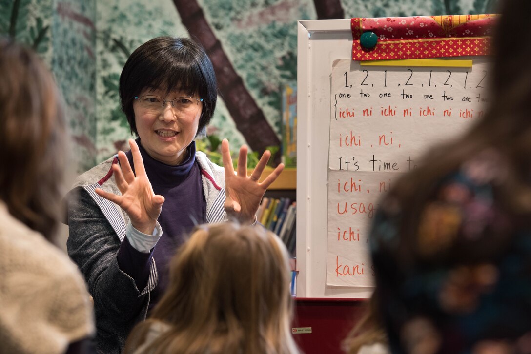 Michiko Wada, Japanese story time instructor, teaches children onomatopoeia animal sounds in Japanese while singing during Japanese story time at Yokota Air Base, Japan, Feb. 25, 2019.