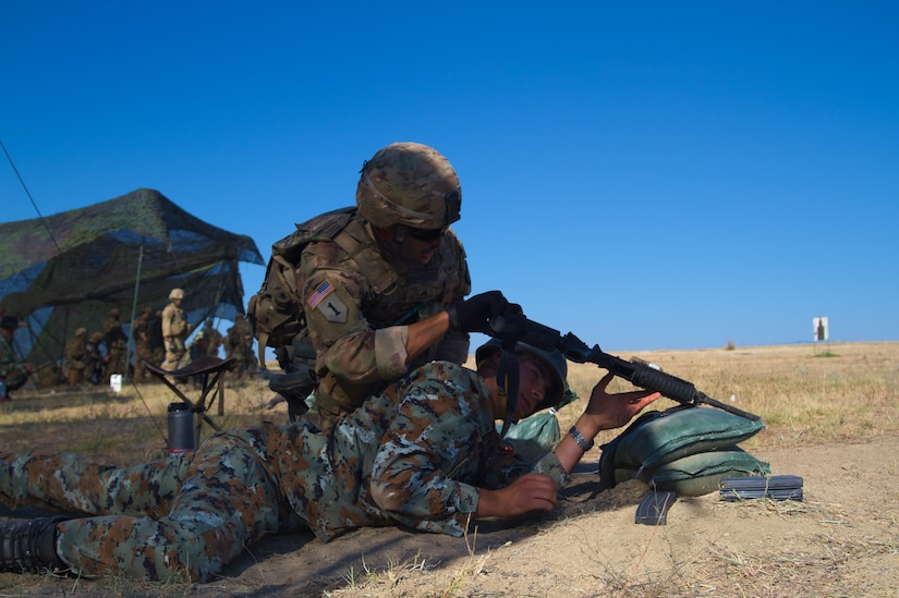 An American soldier checks a Macedonian soldier's rifle during an exercise.