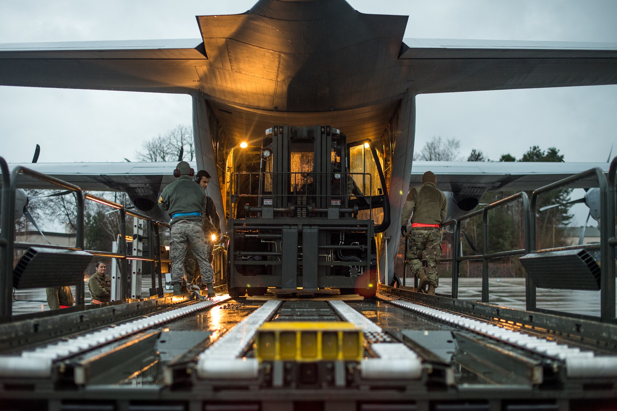 U.S. Air Force Airmen assigned to the 37th Airlift Squadron, 721st Aerial Port Squadron, and the 86th Logistics Readiness Squadron, banded together to load a 10k standard onto a C-130J Super Hercules with a 60k loader on the flightline at Ramstein Air Base, Germany, March 1, 2019. The use of the 60k loader to transfer the 10k standard is a non-traditional method of loading the machine on the aircraft. Airmen practiced the method as part of a week-long exercise in conjunction with Operation Varsity, a wing commander initiative designed to enhance contingency capabilities. (U.S. Air Force photo by Staff Sgt. Devin Boyer)