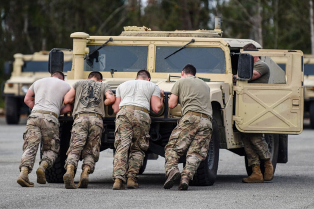 Airmen assigned to the 822d Base Defense Squadron push a Humvee during Scorpion Stakes, Feb. 20, 2019, at Moody Air Force Base, Ga. The competition includes 18 stations such as a ruck, litter carry, simulated hostage rescue, vehicle search. Scorpion Stakes takes all the day-to-day fundamental skills and job knowledge and challenges Airmen on their career training and knowledge while having to physically and mentally overcoming obstacles. (U.S. Air Force photo by Airman 1st Class Taryn Butler)