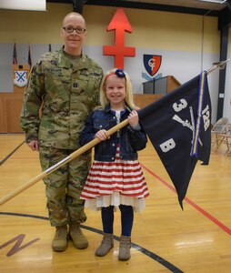 Capt. Amie Kemppainen proudly stands with her daughter Avarie with the guidon from Company B, 3rd Battlion, 126th Infantry.  She took command at a ceremony at the Grand Valley Armory in Wyoming, Michigan on March 2, 2019.  By taking this command, Kemppainen has earned the distinction of being the first female infantry commander in the Michigan National Guard and one of the first in the United States Army.