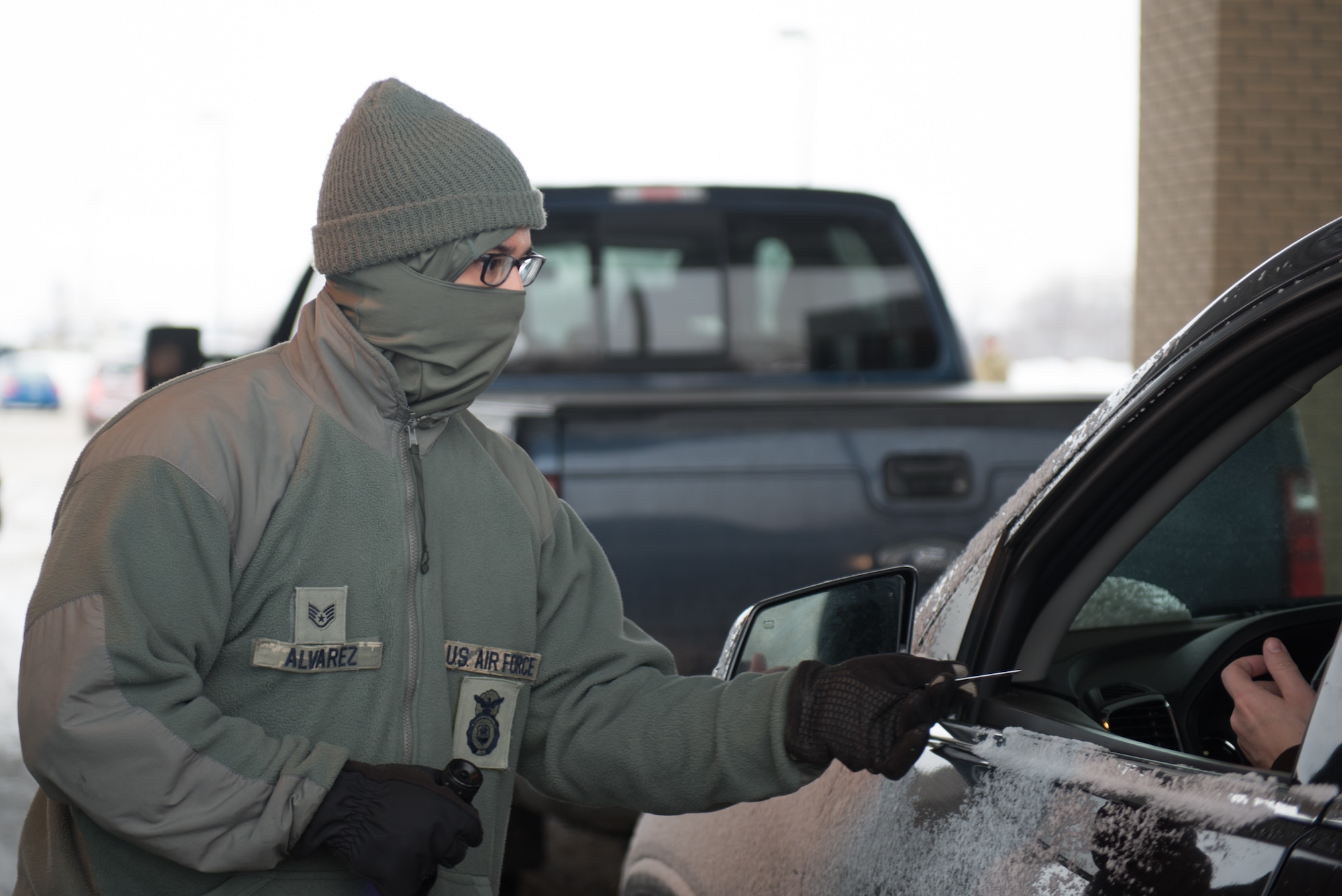 U.S. Air Force Staff Sgt. Xavier Alvarez, 55th Security Force Squadron, waves for a car to proceed at the U.S. Strategic Command gate March 7, 2019, on Offutt Air Force Base. He is one of nearly a dozen guards working the gate in subfreezing temperatures. (U.S. Air Force photo by Tech. Sgt. Rachelle Blake)