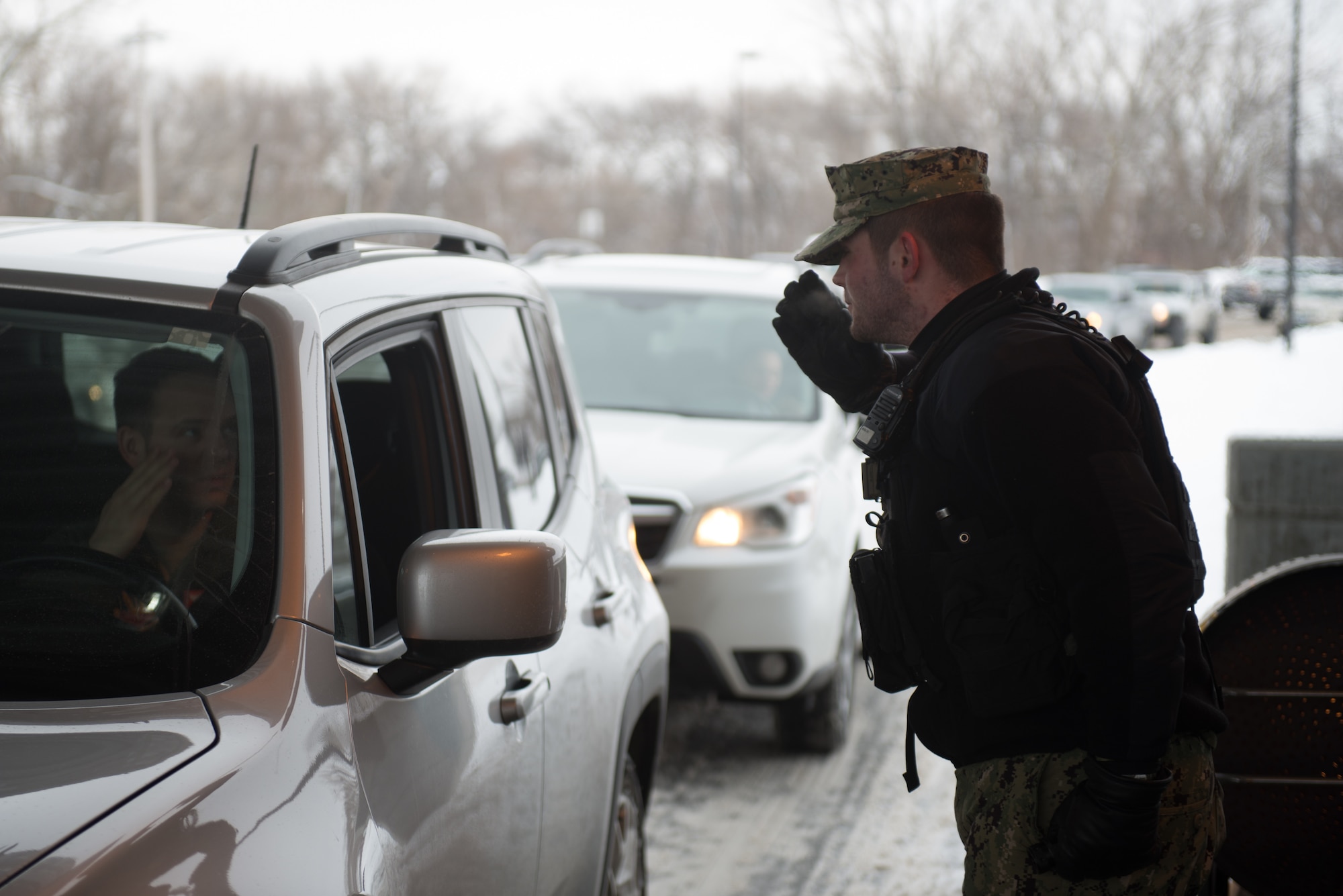 U.S. Air Force Staff Sgt. Gage Taylor, 55th Security Force Squadron, waves for a car to proceed at the U.S. Strategic Command gate March 7, 2019, on Offutt Air Force Base. Taylor is one of nearly a dozen guards working the gate in subfreezing temperatures. (U.S. Air Force photo by Tech. Sgt. Rachelle Blake)
