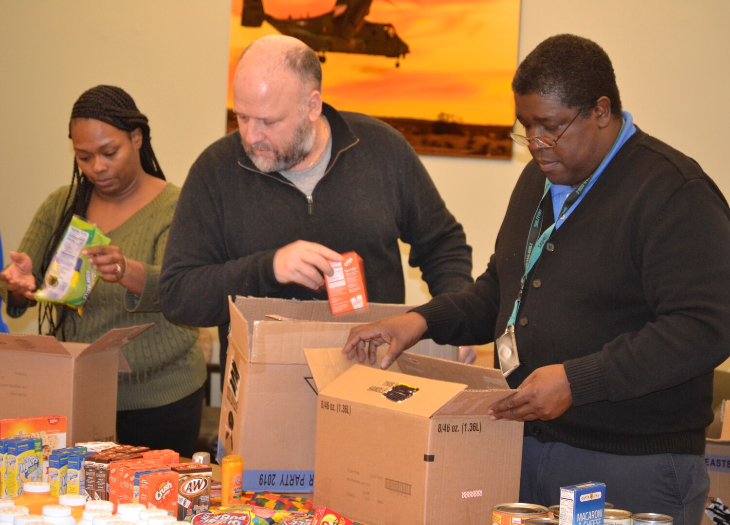 DLA Troop Support Industrial Hardware employees and “IH Troopers” Temecca Baen, Terry Piper and Ron Griffith, left to right, place items in a “Trooper Treat Box” care package March 6, 2019 in Philadelphia.