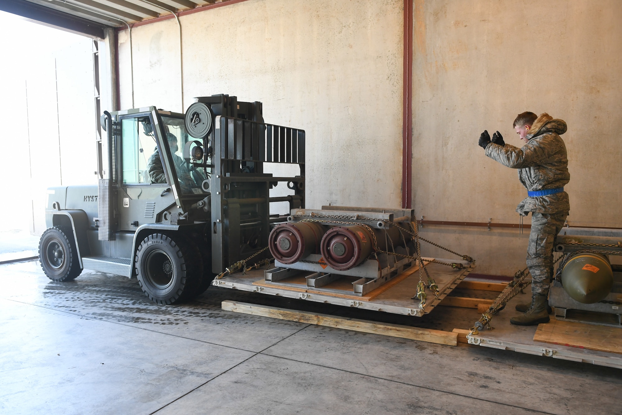 Airman 1st Class Jared Massey, 649th Munitions Squadron, directs the transfer of BLU-109 Penetrator bombs into an earth-covered storage magazine at Hill Air Force Base, Utah, during a readiness inspection Jan. 30, 2019. (U.S. Air Force photo by Cynthia Griggs)