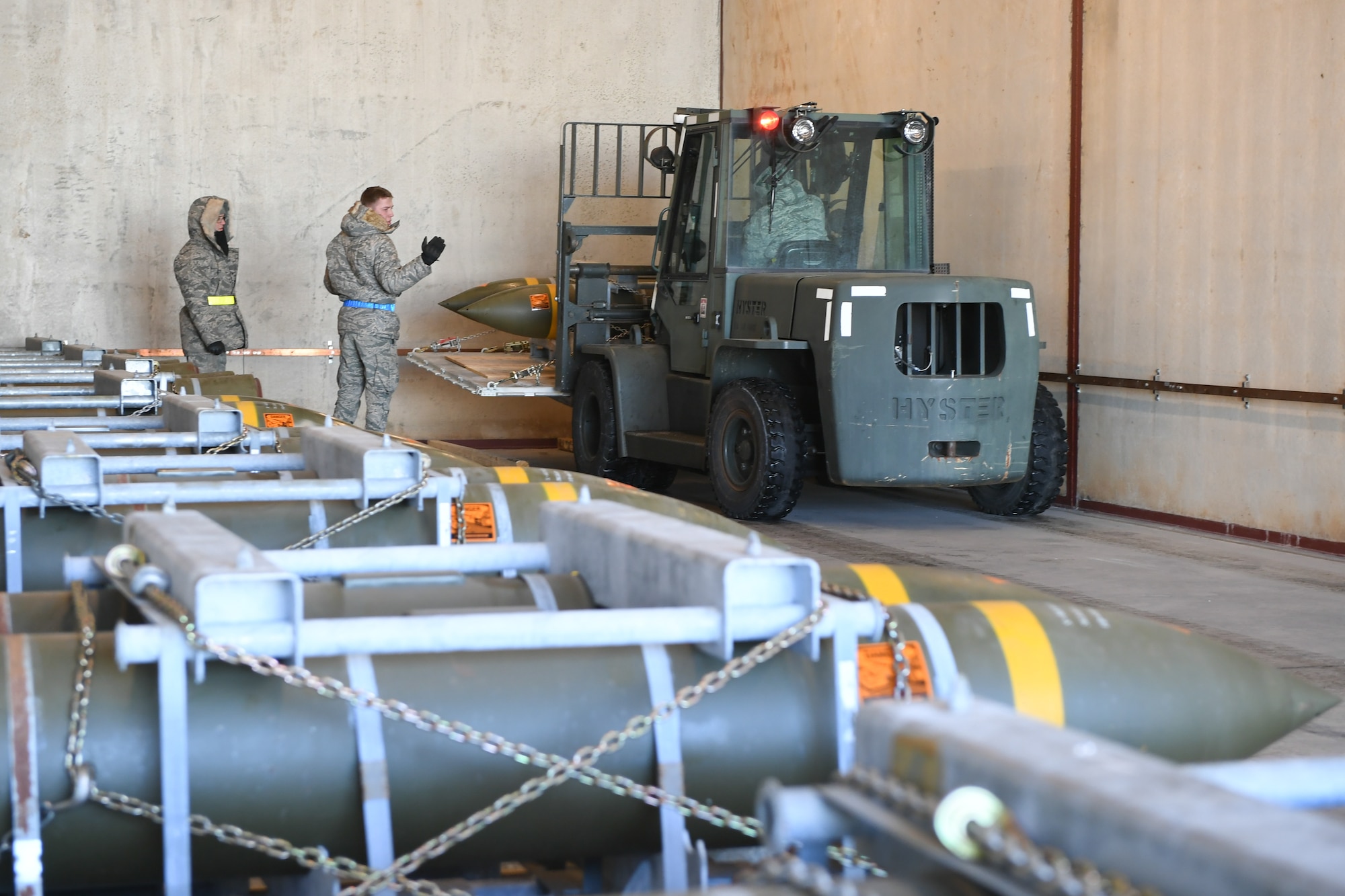 Airman 1st Class Jared Massey, 649th Munitions Squadron, directs the transfer of BLU-109 Penetrator bombs into an earth-covered storage magazine at Hill Air Force Base, Utah, during a readiness inspection Jan. 30, 2019. (U.S. Air Force photo by Cynthia Griggs)