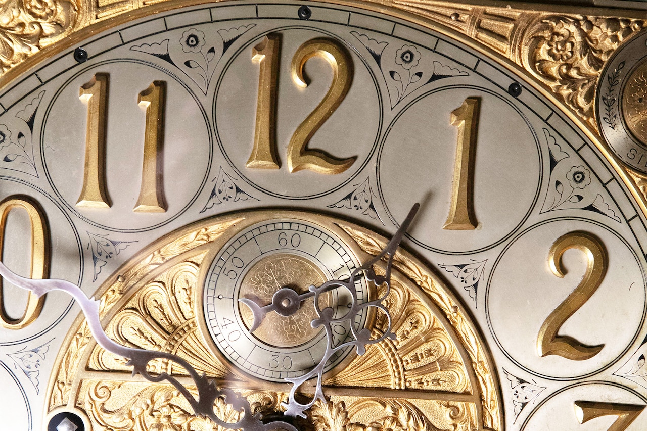 A close-up of an ornate silver and gold clock.