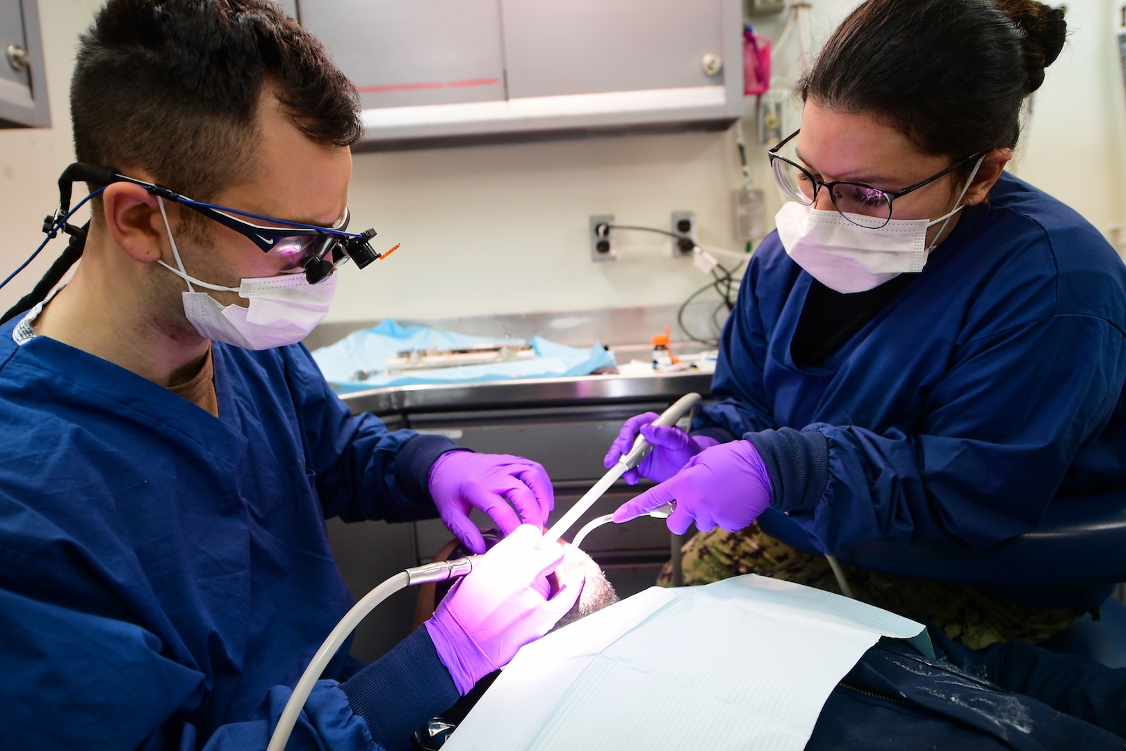 Lt. James Assad, left, and Hospitalman Zoe Guillen conduct a dental exam on a patient in a dental room aboard the Nimitz-class aircraft carrier USS Harry S. Truman (CVN 75).