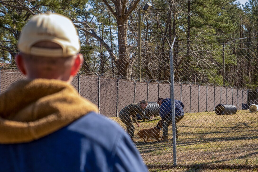U.S. Marine Corps working dog handlers with Headquarters and Headquarters Squadron demonstrate aggression training with a working dog for students at Marine Corps Air Station (MCAS) Cherry Point, North Carolina, March 6, 2019. Students from Salem Baptist Church School in Winston, North Carolina, visited MCAS Cherry Point to learn more about the occupational opportunities within the Marine Corps (U.S. Marine Corps photo by Lance Cpl. Jacob Bertram)