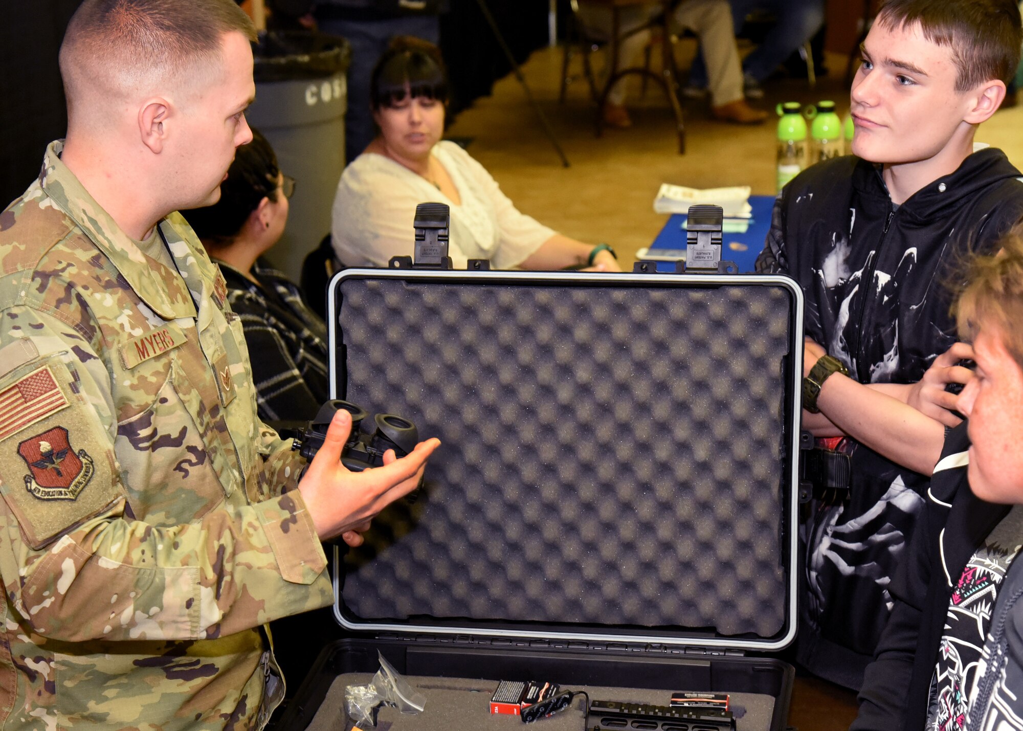 U.S. Air Force Staff Sgt. Benjamin Myers, 315th Training Squadron instructor, converses with students about the functions of night vision goggles, at Careers Y’all, a youth career fair, at the McNease Convention Center, in San Angelo, Texas, March 6, 2019. Night vision goggles use ambient light such as moonlight and starlight to provide vision in low light situations. (U.S. Air Force photo by Airman 1st Class Abbey Rieves/Released)