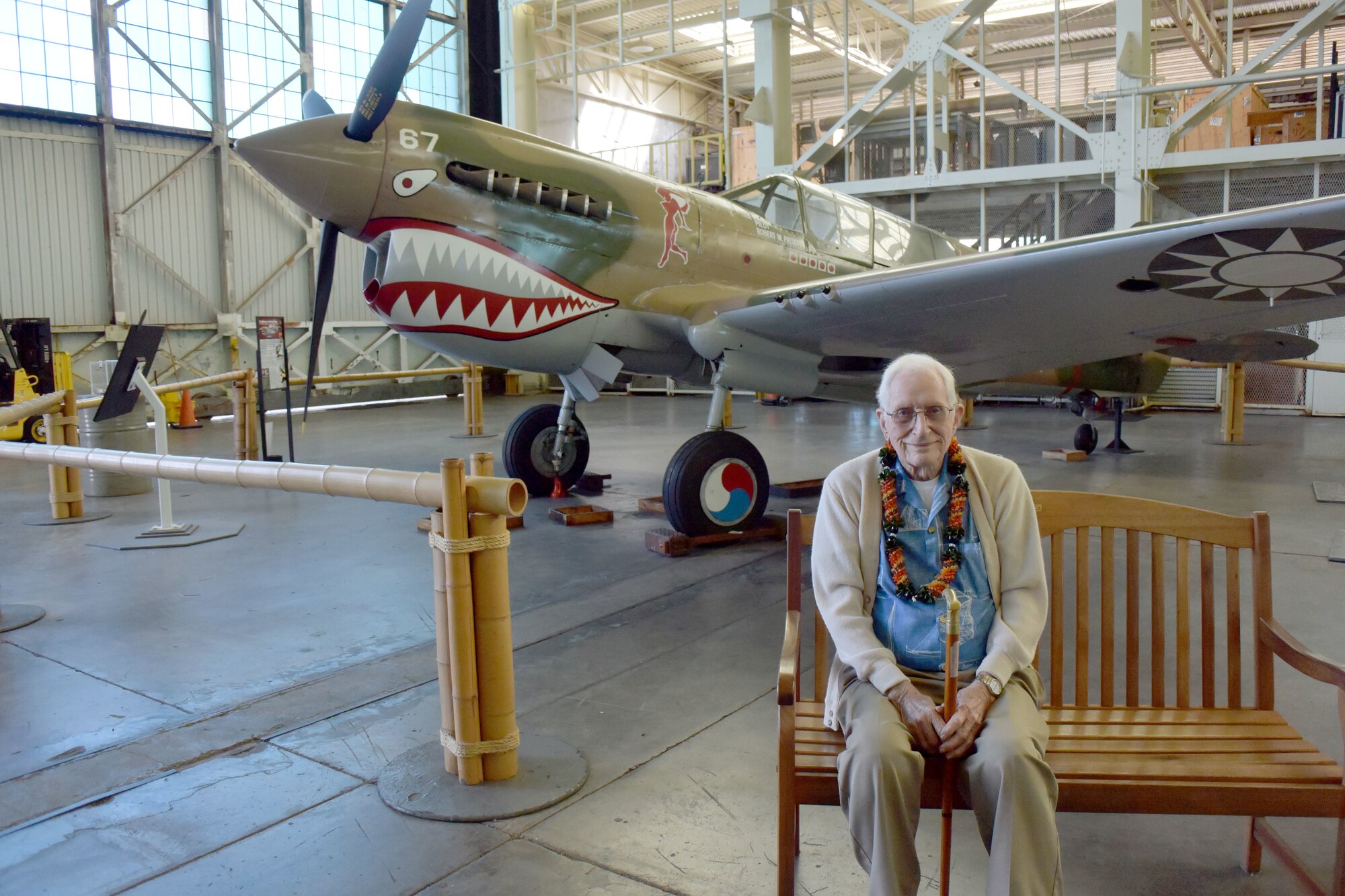 Retired Air Force Col. Bruce Hunt (center front), poses for a photo in front of a P-40 static display  at the Pacific Aviation Museum on Ford Island, Hawaii, Feb. 23, 2019. Hunt is a decorated World War II and Vietnam War veteran who served heroically and persevered through many challenges most people will never face in their lifetime. (U.S. Air Force photo by Capt. Veronica Perez)