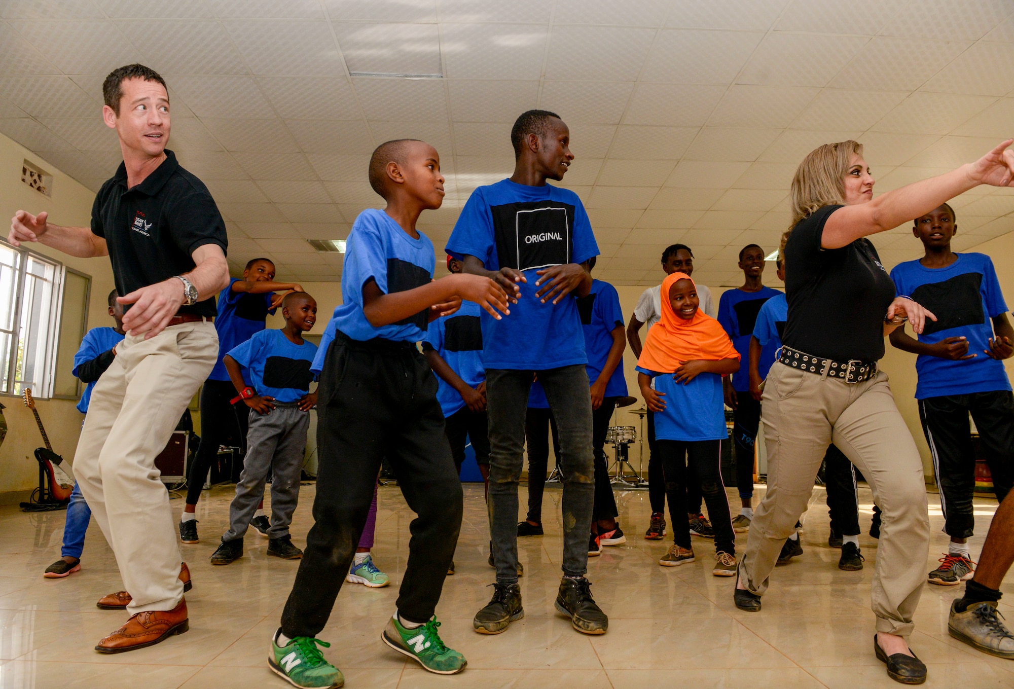 U.S. Airmen assigned to the U.S. Air Forces in Europe Band Touch N' Go dance along with students at the Gisimba Memorial Centre in Kigali, Rwanda, March 6, 2019. As musical ambassadors, members of the band can reach audiences that traditional military members can't. They travel the world to build cultural bridges, and honor and preserve cultural heritage. (U.S. Air Force photo by Tech. Sgt. Timothy Moore)