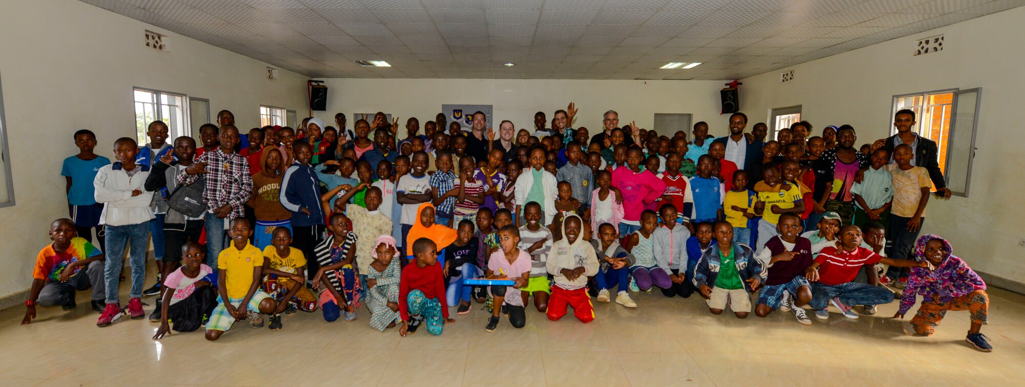 U.S. Airmen assigned to the U.S. Air Forces in Europe Band Touch N' Go pose for a photo with students and staff members at the Gisimba Memorial Centre in Kigali, Rwanda, March 6, 2019. As musical ambassadors, members of the band can reach audiences that traditional military members can't. They travel the world to build cultural bridges, and honor and preserve cultural heritage. (U.S. Air Force photo by Tech. Sgt. Timothy Moore)