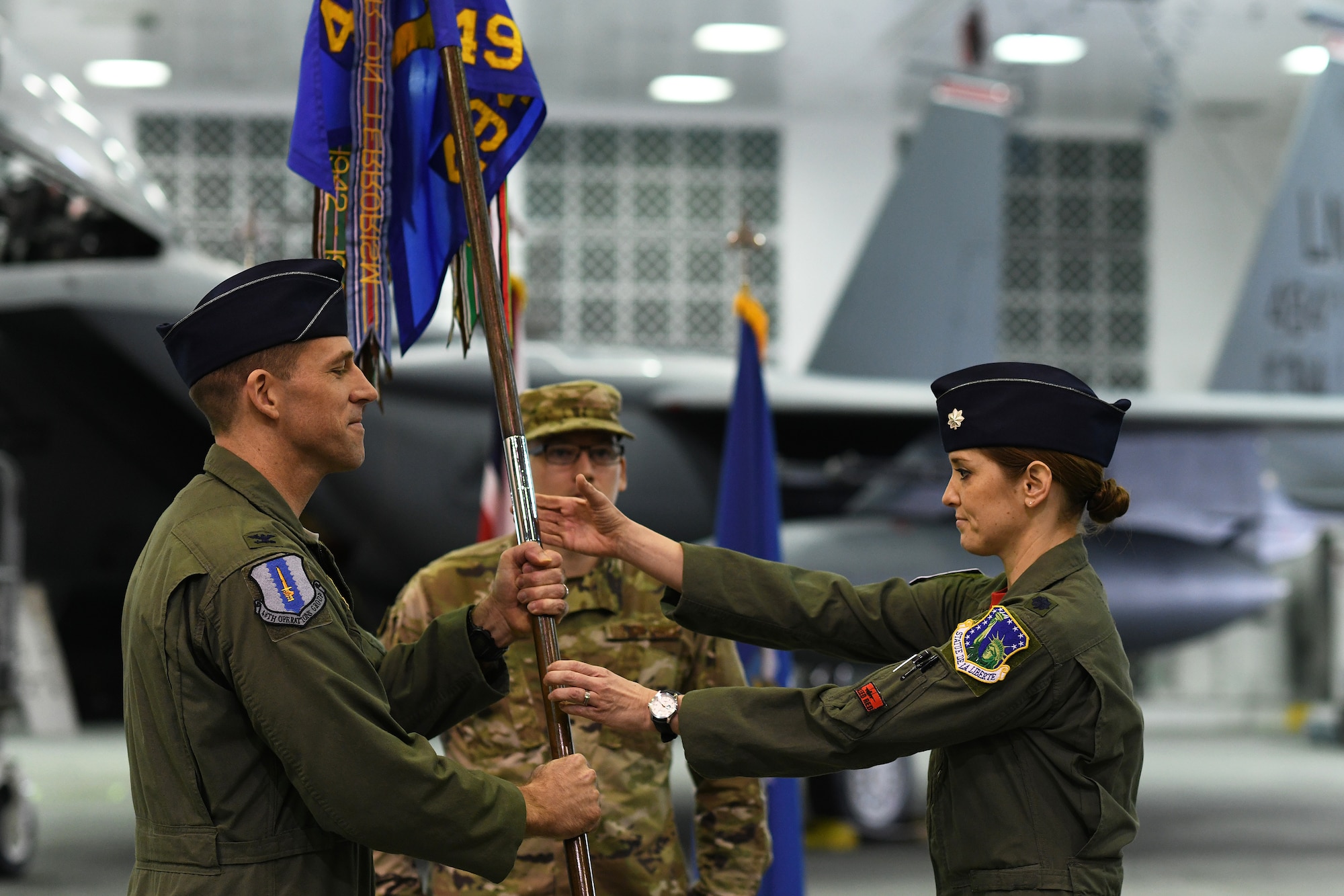 Lt. Col. Jaina L. Donberg, incoming494th Fighter Squadron commander, recieves the guidon from Col. Jason Camilletti, 48th Operations Group commander, during the change of command ceremony at Royal Air Force Lakenheath, England, March 8, 2019. The passing of the guidon symbolizes the transfer of responsibility for a unit from one commanding officer to another. (U.S. Air Force photo by Airman 1st Class Shanice Williams-Jones)