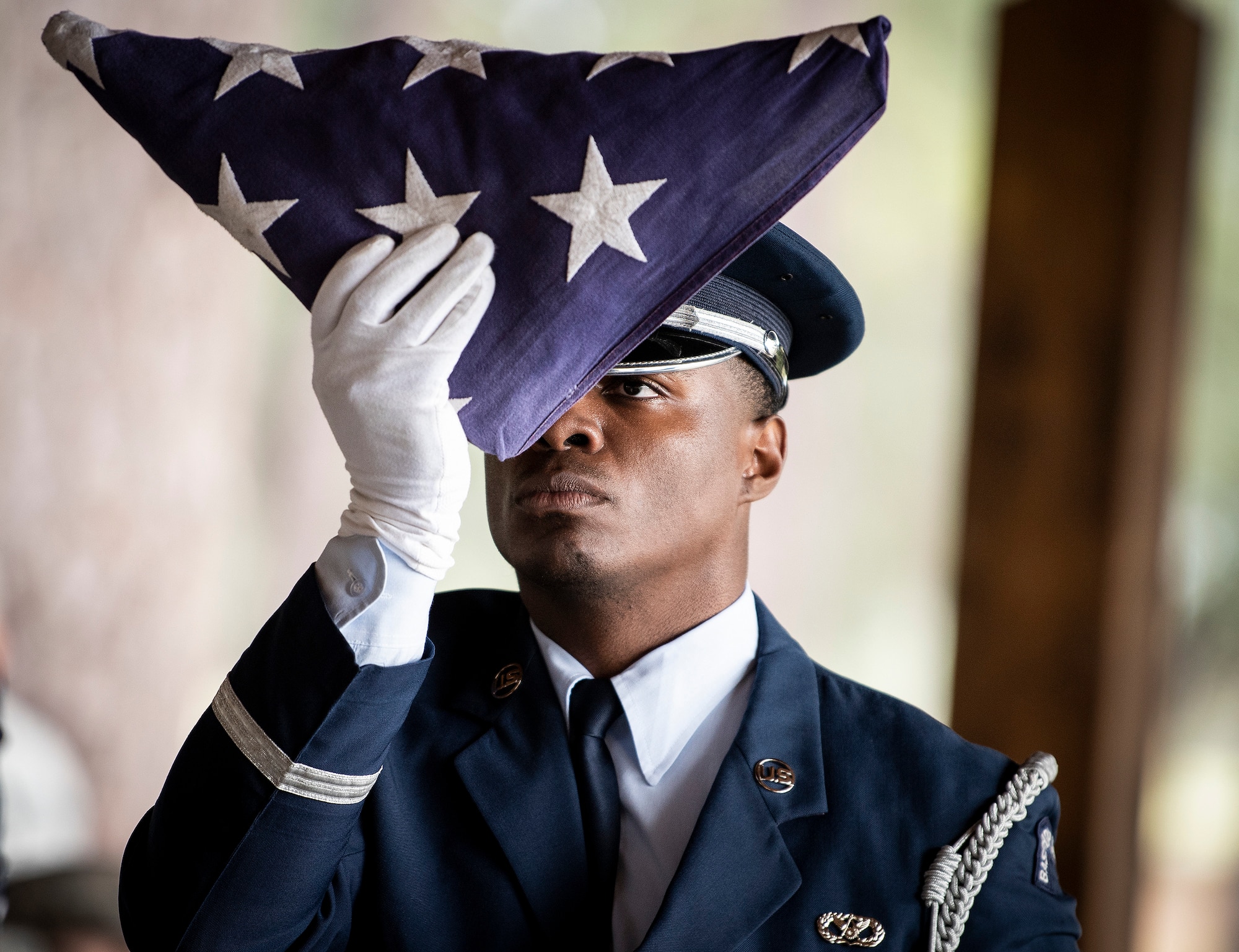 An Airman inspects a folded flag during an Honor Guard graduation ceremony