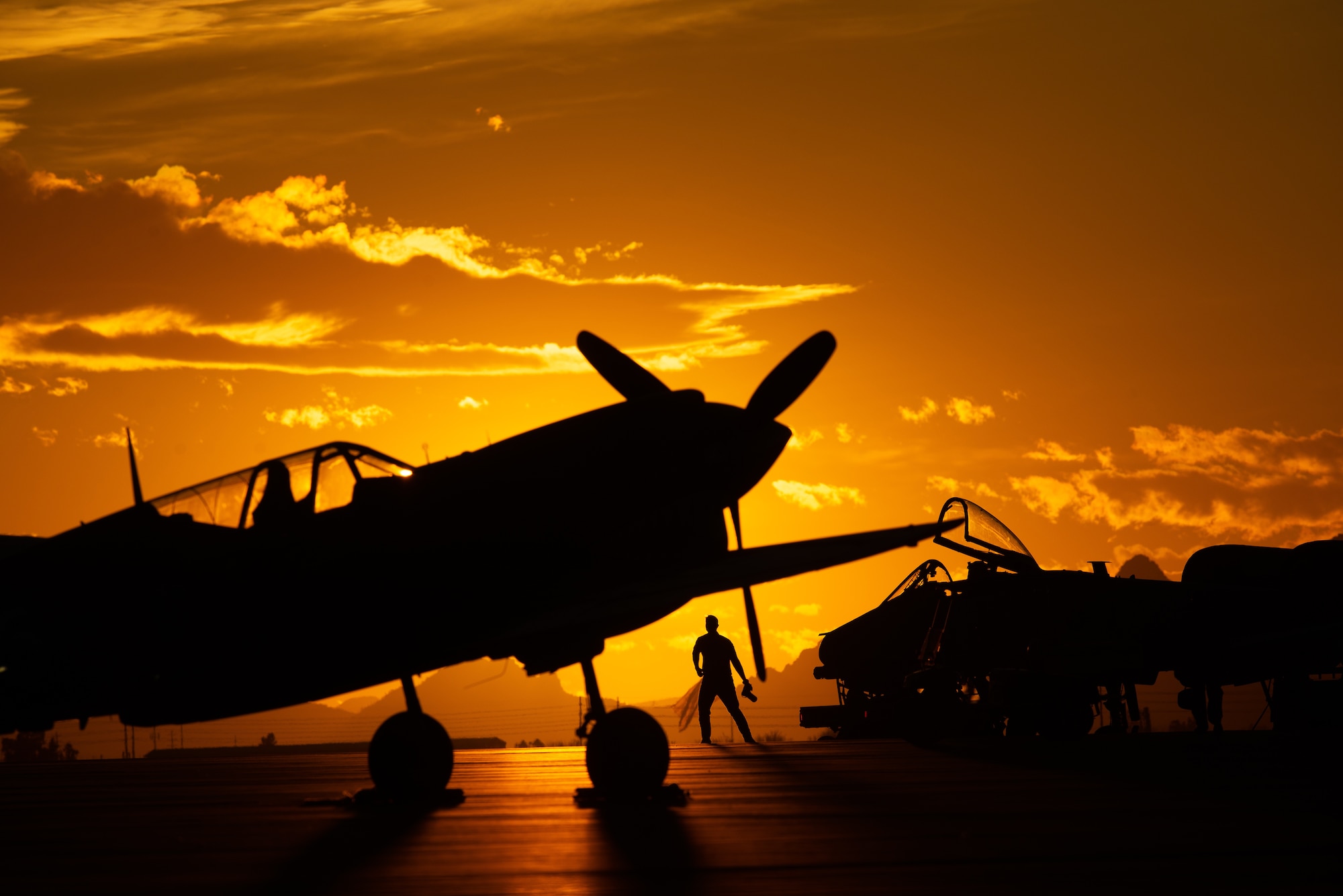 Sunset silhouette of planes on a flightline