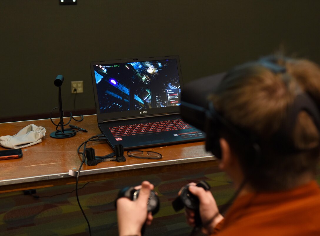 A high school student pilots a space ship using virtual reality at Mississippi State University’s Engineering Day March 4, 2019, in Starkville, Mississippi. VR technology is one of the many ways the Air Force is revolutionizing the way pilots are trained. (U.S. Air Force photo by Senior Airman Beaux Hebert)