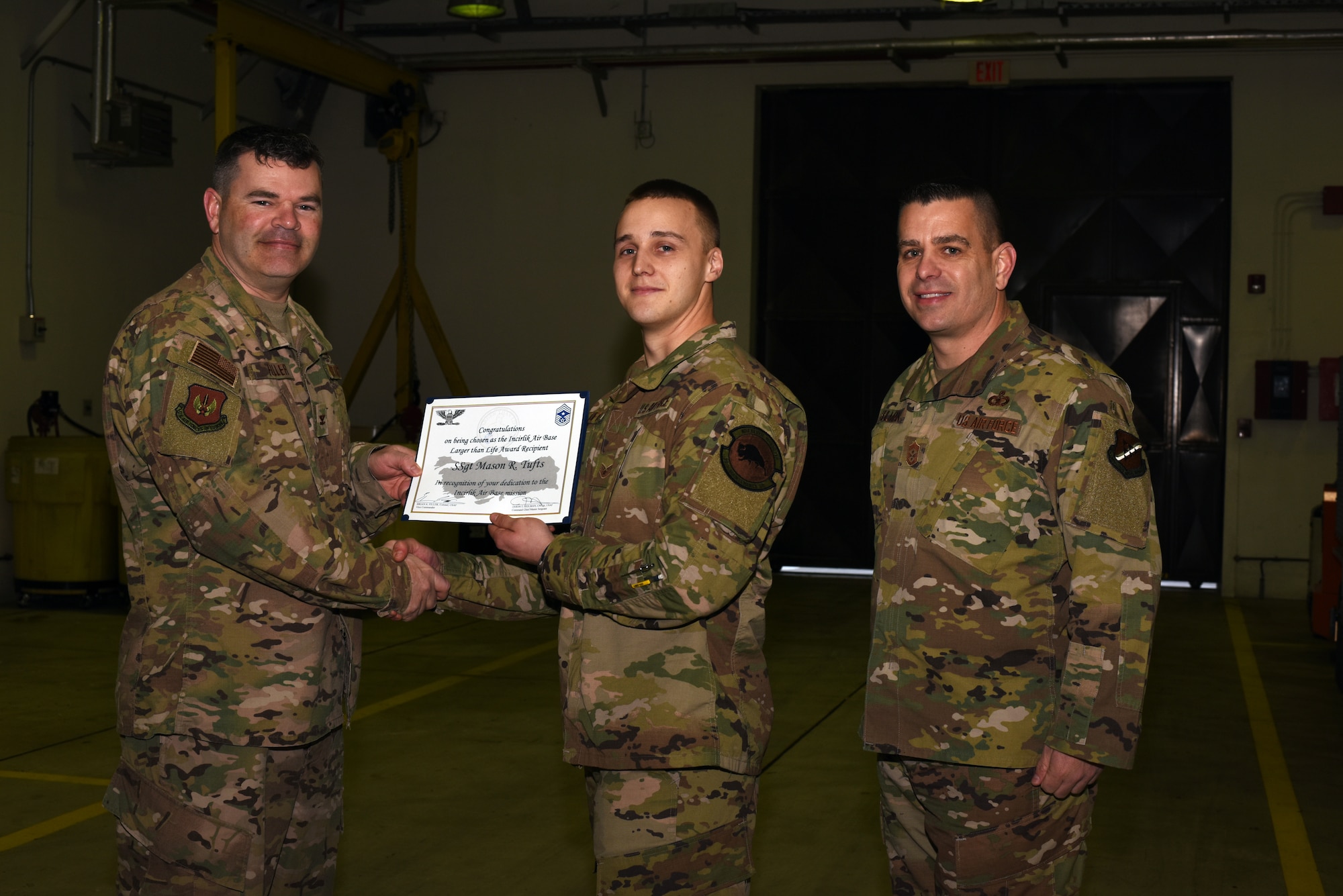 Col. Brian A. Filler, 39th Air Base Wing vice commander, left, and Chief Master Sgt. Jason T. Heilman, 39th Air Base Wing command chief, right, present the Larger Than Life Award to Staff Sgt. Mason Tufts, 39th Maintenance Squadron aerospace ground equipment journeyman, at Incirlik Air Base, Turkey, Mar. 6, 2019.