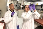 two people look at scientific equipment