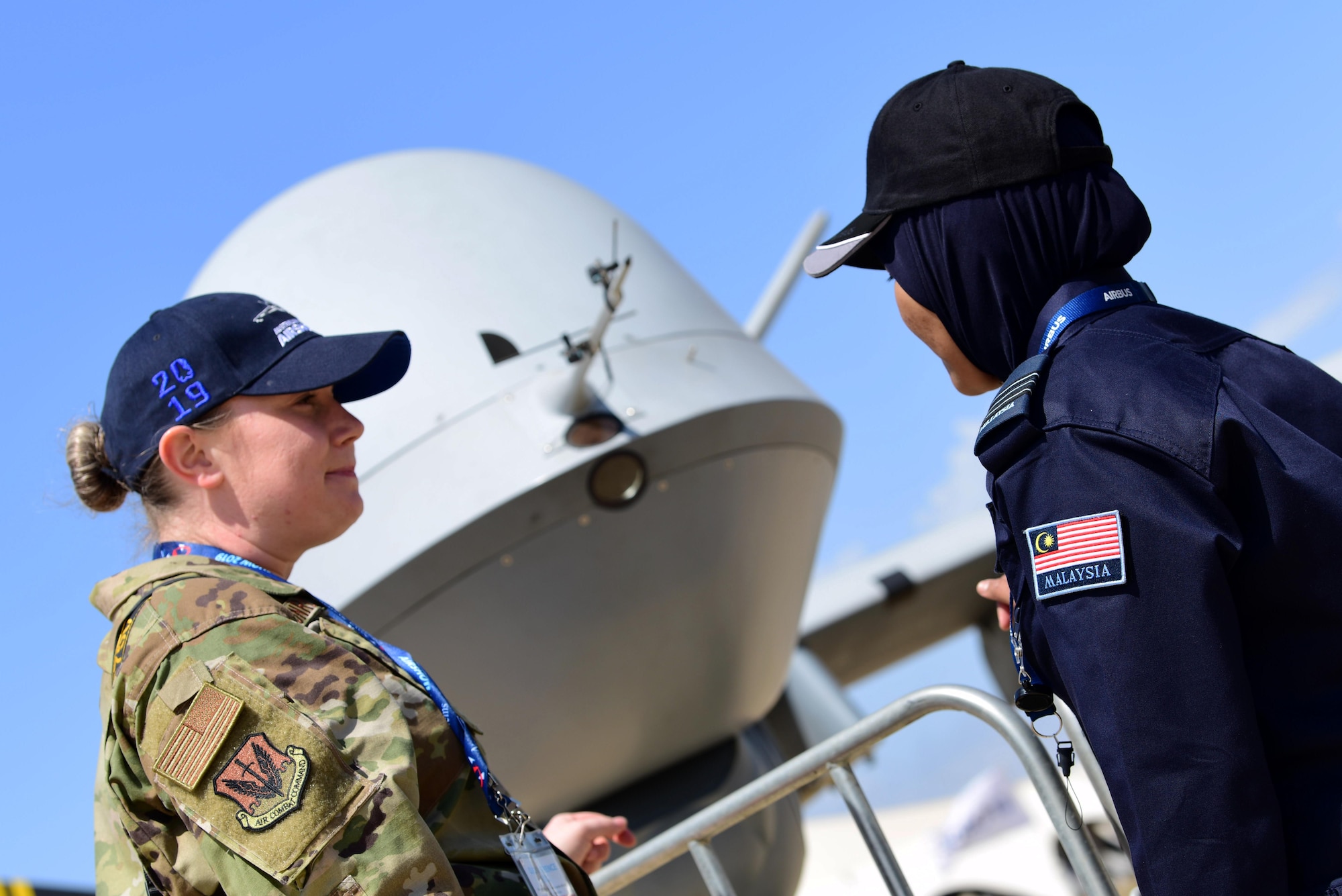 Capt. Annabel Monroe, 432nd Wing/432nd Air Expeditionary Wing Public Affairs officer, talks with an airshow visitor about the MQ-9 Reaper mission during the Australian International Airshow, Feb. 26, 2019, in Geelong, Victoria, Australia. Displaying the aircraft at the Australian International Airshow is not only an opportunity to help RPA Airmen explain their role in national security, but also provides the chance for the U.S. Air Force to show their support for our coalition partners in the Indo-Pacific region. (U.S. Air Force photo by Airman 1st Class Haley Stevens)