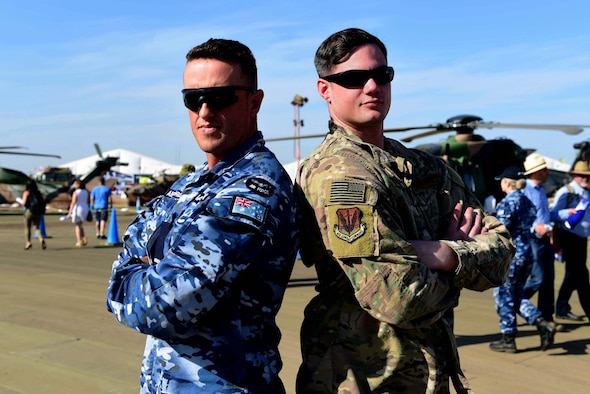 Aircraftman James Bayley with the Royal Australian Air Force, and Staff Sgt. Joshua with the United States Air Force display their national flags during the Australian International Airshow, Feb. 26, 2019, in Geelong, Victoria, Australia. In line with the focus of strengthening the relationship between the Australian Defence Force and U.S. military, the U.S. Air Force and Creech Airmen brought the MQ-9 Reaper to be displayed during this airpower demonstration. (U.S. Air Force photo by Airman 1st Class Haley Stevens)